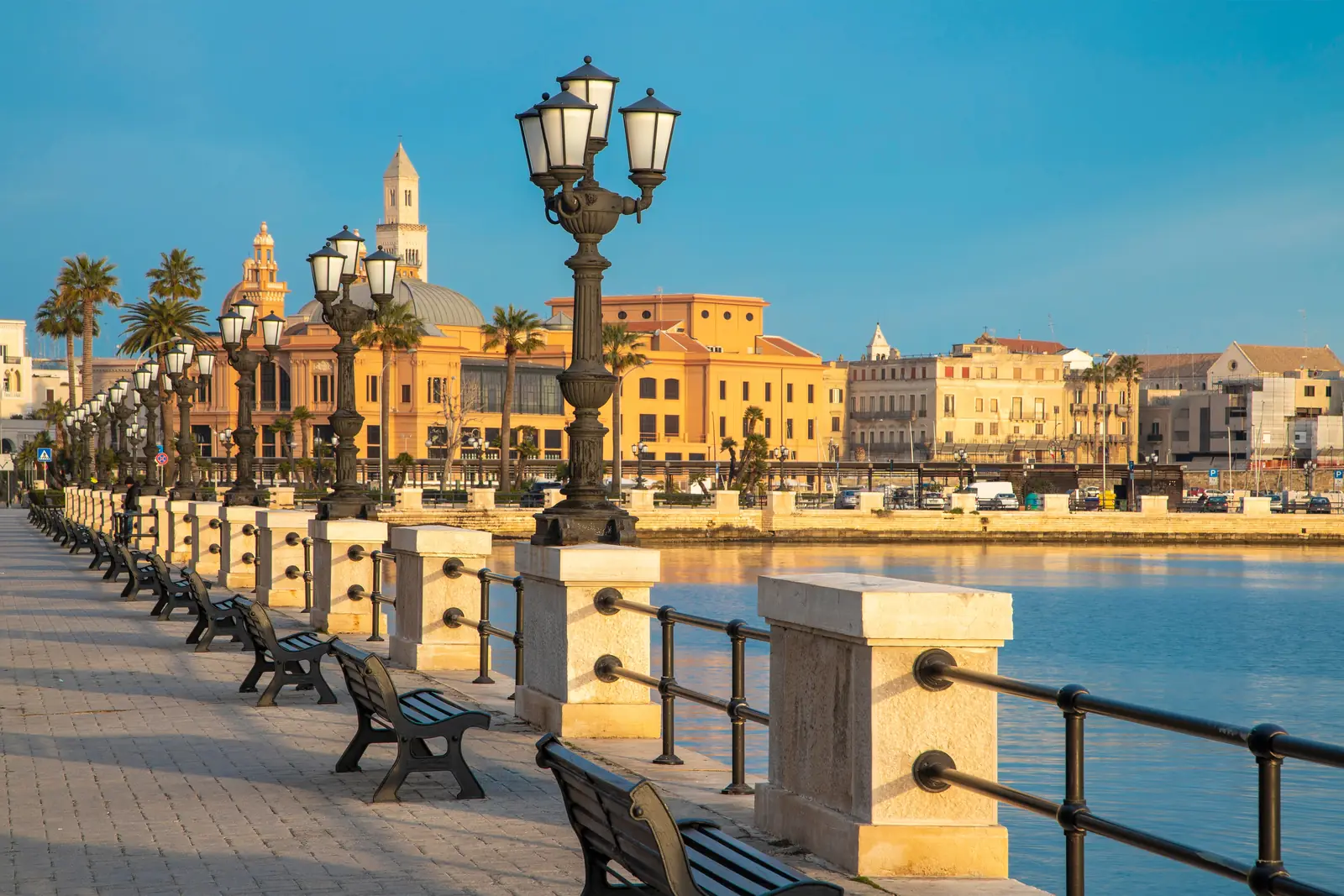 The Bari waterfront promenade with its lamps, in warm evening light.