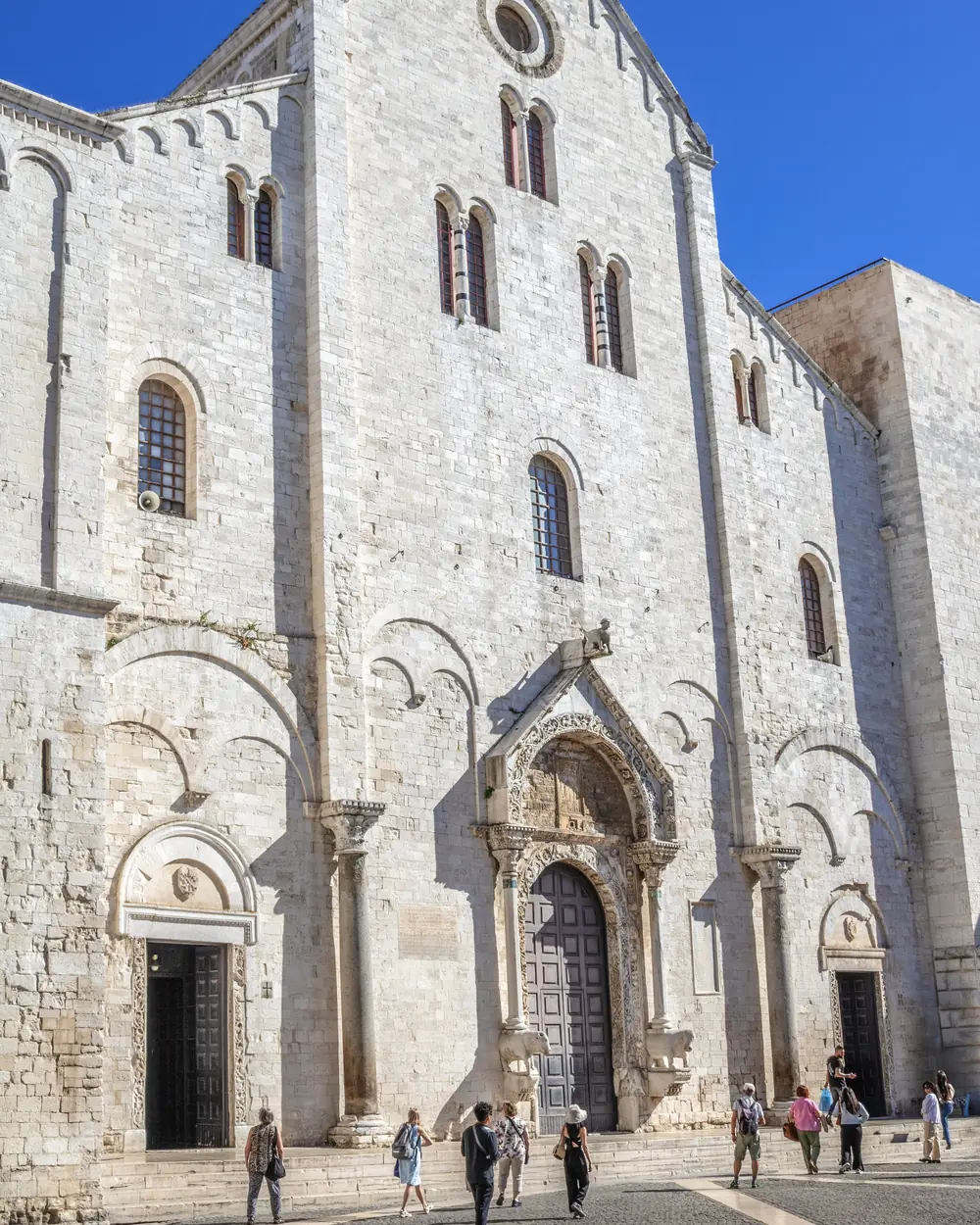 The pale stone façade of the Basilica of San Nicola in the old town of Bari.