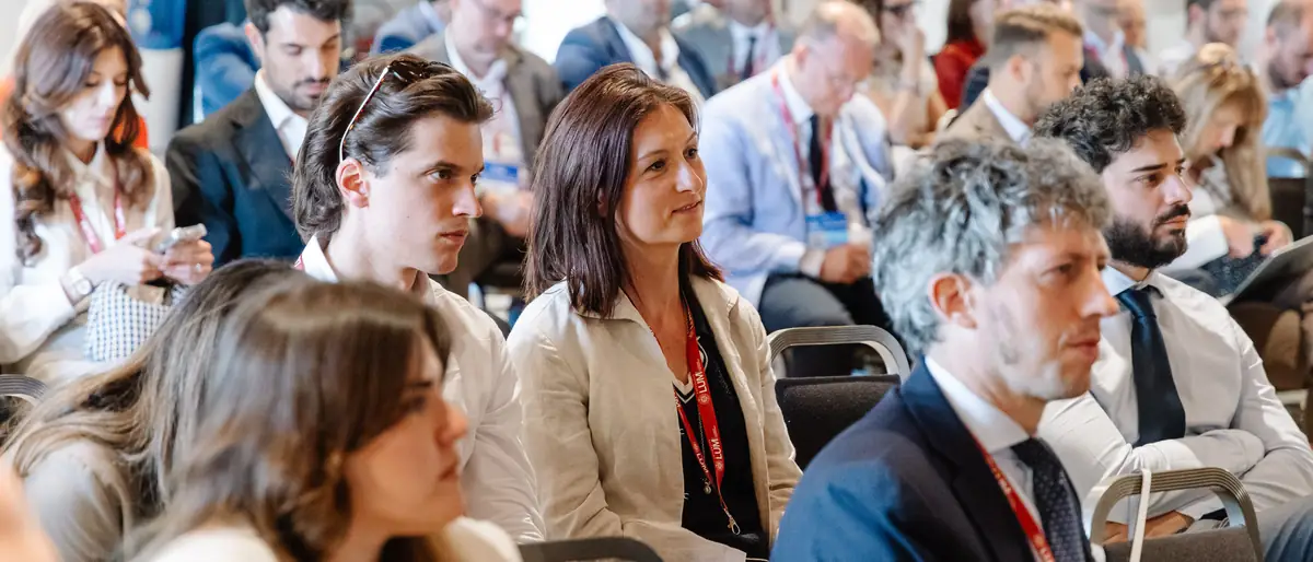 Researchers in the audience following a plenary session at the 2026 edition.